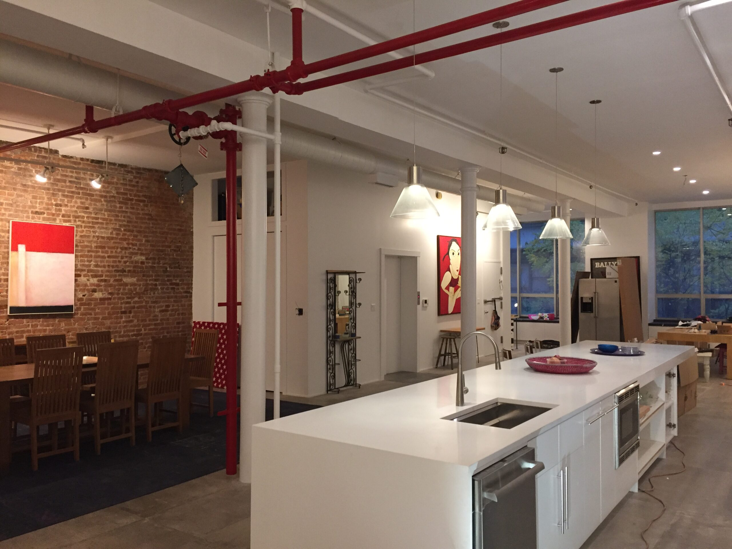 NYC loft kitchen renovation with large island and exposed brick by RDDNY Design Build